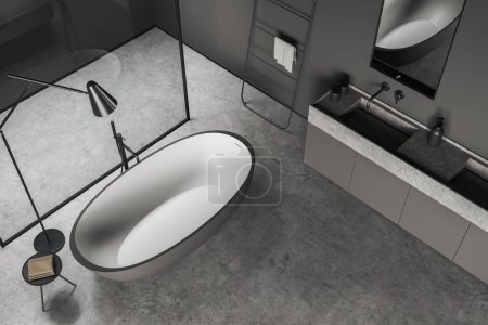 Foto de Vista superior del interior del cuarto de baño oscuro con bañera, lavabo y ducha detrás de la partición de vidrio, piso de hormigón gris. Moderno estudio de hotel. Renderizado 3D - Imagen libre de derechos