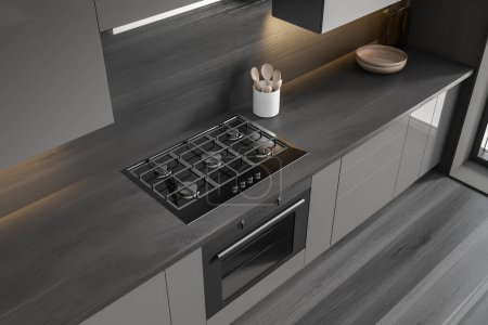 Téléchargez les photos : Top view of dark kitchen interior with deck and appliances, oven with stove, spoon and plate. Cooking space in modern apartment. 3D rendering - en image libre de droit