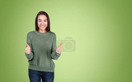 Photo for Young happy woman showing thumb up on green background. Concept of approval and recommend. Blank copy space - Royalty Free Image
