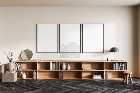 Téléchargez les photos : Beige living room interior with long drawer and art decoration, front view, stool and stand on black hardwood floor. Three mock up posters in row. 3D rendering - en image libre de droit