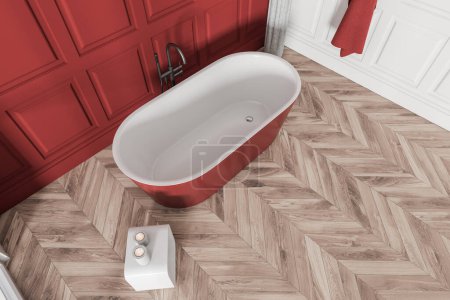 Foto de Vista superior del interior de la sala de baño con bañera roja en el suelo de madera de frondosas claras. Lavadero con bañera, vela y toalla en la pared. Renderizado 3D - Imagen libre de derechos