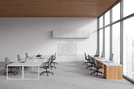 Photo for White business interior with shared table and laptop. Coworking zone with pc computer, meeting area and panoramic window on city view. 3D rendering - Royalty Free Image