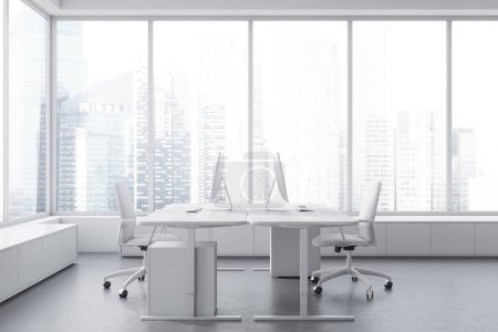 Foto de Interior de oficina blanco con sillones y ordenador PC en dos escritorios, suelo de hormigón gris. Esquina de coworking con ventana panorámica sobre rascacielos. Renderizado 3D - Imagen libre de derechos
