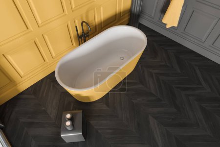 Foto de Vista superior del interior de la sala de baño con bañera amarilla en el suelo de madera negra. Lavadero con bañera, vela y toalla en la pared. Renderizado 3D - Imagen libre de derechos