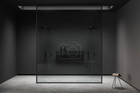 Foto de Dark bathroom interior with double shower behind glass partition, grey concrete floor. Towel table, modern hotel studio, front view. 3D rendering - Imagen libre de derechos
