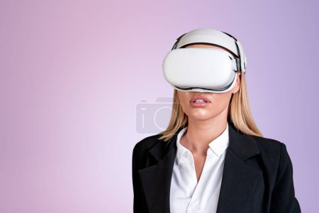 Photo for Businesswoman wearing vr headset is watching at metaverse reality. Empty pink wall in background. Concept of modern technology and progress in business, copy space, ambitious business person - Royalty Free Image