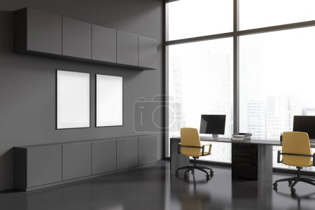 Foto de Interior oscuro de negocios con sillones y ordenador PC en el escritorio, vista lateral. Oficina de trabajo con estantes y ventana panorámica en rascacielos. Dos pósters de tela maqueta. Renderizado 3D - Imagen libre de derechos