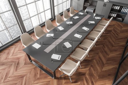 Téléchargez les photos : Top view of meeting room interior with armchairs and tools on board, hardwood floor. Business conference room and cabinet with documents, panoramic window on Singapore city view. 3D rendering - en image libre de droit