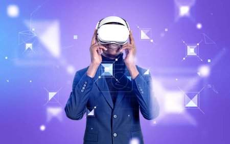 Foto de Hombre de negocios negro en traje que trabaja en gafas vr, holograma digital de campos de información y bloques sobre fondo púrpura. Concepto de metaverso y almacenamiento de datos - Imagen libre de derechos