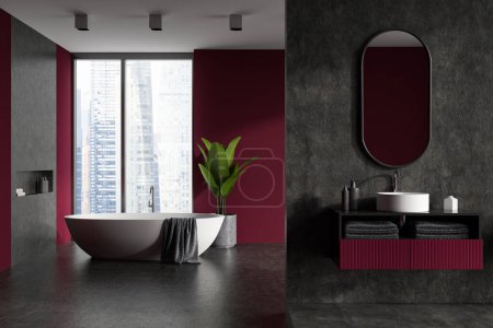 Foto de Interior del baño oscuro con lavabo, espejo y toalla, bañera. Botella de jabón y difusor de caña en cubierta, piso de hormigón gris. Visualización de ventana panorámica 3D - Imagen libre de derechos