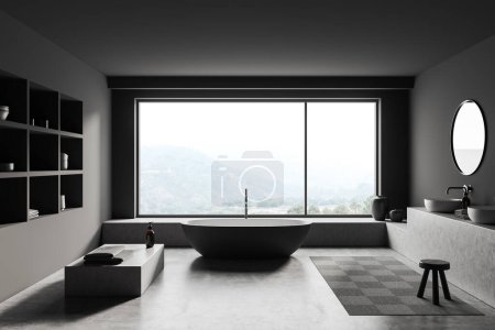 Téléchargez les photos : Dark bathroom interior with bathtub on grey concrete floor. Sink with mirror, shelf and podium with accessories, panoramic window on countryside. 3D rendering - en image libre de droit