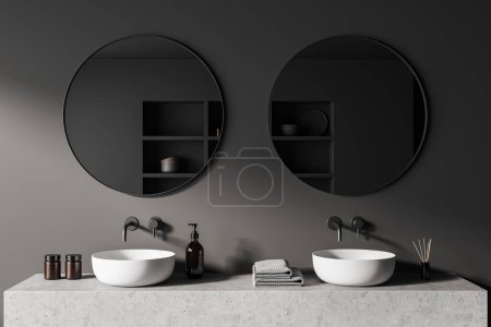Foto de Dark bathroom interior with two sink and round mirror, grey concrete deck with bathing accessories, reed diffuser and bath gel. 3D rendering - Imagen libre de derechos