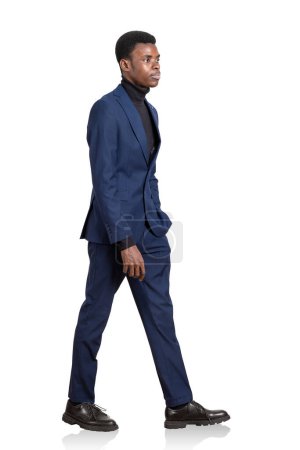 Photo for African American businessman in blue suit, confident look, walking isolated over white background. Concept of career development and international company - Royalty Free Image