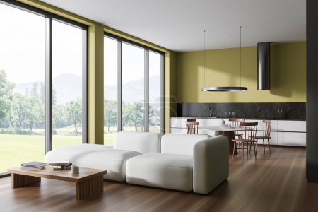 Téléchargez les photos : Interior of stylish living room with yellow walls, wooden floor, white sofa and kitchen with dining table and white cabinets. Panoramic window with blurry mountain view. 3d rendering - en image libre de droit