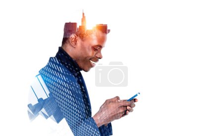 Foto de Perfil de hombre de negocios negro joven con una sonrisa feliz navegar por el teléfono inteligente, rascacielos de negocios doble exposición. Concepto de comunicación en línea. Copiar espacio - Imagen libre de derechos