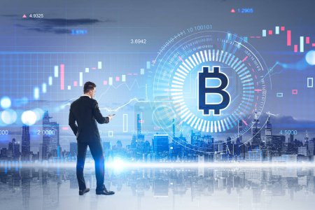 Photo for Businessman back view with mobile phone, cryptocurrency hologram with bitcoin and New York skyline. Virtual hud screen with binary and financial analysis. Concept of online trading - Royalty Free Image