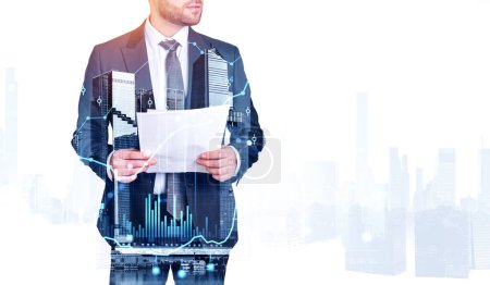 Photo for Unrecognizable businessman holding documents in city with double exposure of blurry graphs. Concept of stock market and trading - Royalty Free Image