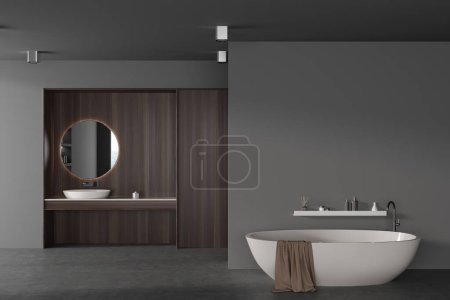 Dark hotel bathroom interior with bathtub on grey concrete floor. Sink with round mirror and minimalist accessories, mock up empty wall. 3D rendering