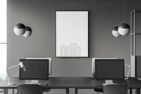 Téléchargez les photos : Intérieur d'affaires sombre avec bureau partagé et ordinateur PC. Coworking avec fenêtre panoramique sur campagne. Affiche de toile maquillée sur mur gris. rendu 3D - en image libre de droit