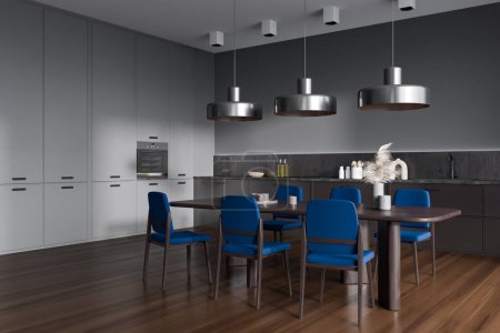 Photo for Dark kitchen interior with blue chairs and dining table on hardwood floor, side view. Kitchenware on deck and oven. Modern open space eating corner. 3D rendering - Royalty Free Image