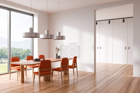 Foto de Interior comedor blanco con mesa y sillas naranjas, suelo de madera. Ventana panorámica con vistas al campo. Sala de estar minimalista con decoración. Renderizado 3D - Imagen libre de derechos