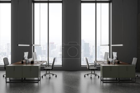 Téléchargez les photos : Intérieur de bureau sombre avec ordinateur PC sur bureau avec fauteuils, sol en béton gris. Zone de coworking avec fenêtre panoramique sur les gratte-ciel de Paris. rendu 3D - en image libre de droit