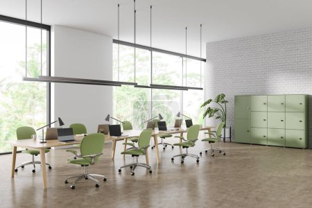 Foto de Esquina de elegante oficina de espacio abierto con paredes de ladrillo blanco, suelo de hormigón, mesas de ordenador largas, gabinete verde y grandes ventanales con vista tropical. renderizado 3d - Imagen libre de derechos
