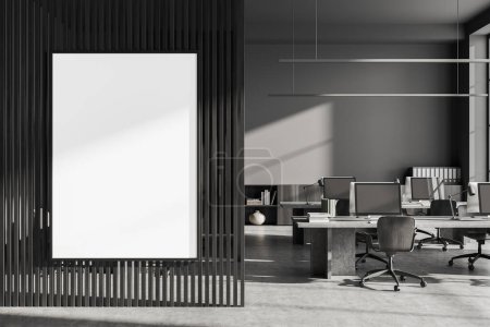 Foto de Interior de oficina oscuro con sillones, escritorio con ordenadores PC en suelo de hormigón gris. Aparador con documentos y decoración. Partición con gran maqueta de póster de lona. Renderizado 3D - Imagen libre de derechos