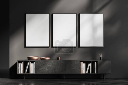 Foto de Interior de la sala de estar negro con aparador de mármol y biblioteca en casa. Diseño escandinavo minimalista y suelo de hormigón gris. Tres carteles de lona en fila. Renderizado 3D - Imagen libre de derechos