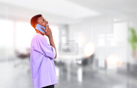 Photo for African American handsome businessman wearing casual wear is talking on smartphone at office workplace in background. Concept of working process, distance work, important conference call - Royalty Free Image