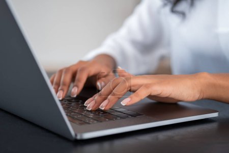 Photo for Black businesswoman fingers typing on laptop, closeup focused. Online communication and web education. Concept of e-learning - Royalty Free Image