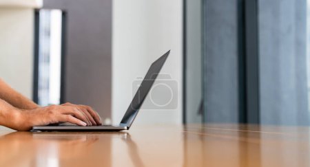 Photo for Businessman fingers typing on laptop, texting in computer on wooden table at home living room. Concept of internet online shopping, website and digital technology - Royalty Free Image