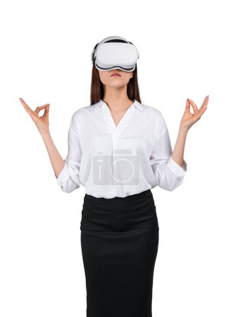 Téléchargez les photos : Jeune femme d'affaires portant des lunettes vr casque, debout en position de yoga avec geste mudra, isolé sur fond blanc. Concept de métaverse et de méditation - en image libre de droit