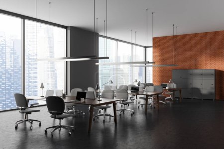 Photo for Dark modern open space brick office interior with grey armchairs, side view table with laptop in row, grey concrete floor. Coworking corner and panoramic window on skyscrapers. 3D rendering - Royalty Free Image