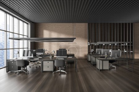 Foto de Interior oscuro de la oficina con sillones y computadora PC en el escritorio en fila, piso de madera dura. Zona de coworking de espacio abierto con estante y ventana panorámica sobre rascacielos. Renderizado 3D - Imagen libre de derechos
