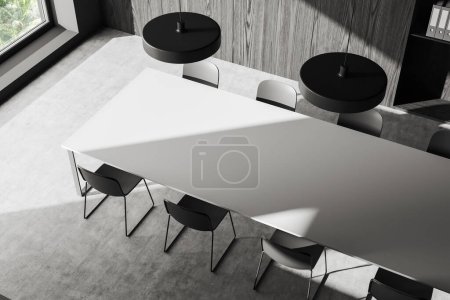 Téléchargez les photos : Vue de dessus de l'intérieur sombre de la salle d'affaires avec chaises et table de réunion blanche, sol en béton gris. Coin conférence bureau avec étagère et fenêtre. rendu 3D - en image libre de droit