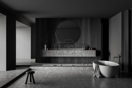 Photo for Dark bathroom interior with bathtub, mixer mounted, double sink and round mirror, hotel bathing accessories on deck, foot towel on podium, grey concrete floor. 3D rendering - Royalty Free Image