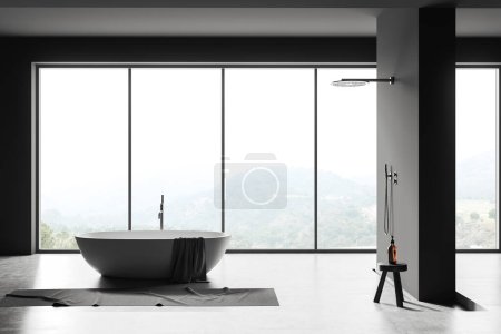 Téléchargez les photos : Intérieur salle de bain sombre avec baignoire, douche et tabouret avec bouteille de bain, serviette de pieds sur sol en béton gris. Fenêtre panoramique sur campagne. rendu 3D - en image libre de droit