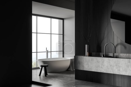 Photo for Dark bathroom interior with bathtub in the corner, side view, sink and mirror and decoration, grey concrete floor. Panoramic window on countryside. 3D rendering - Royalty Free Image