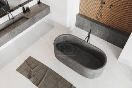 Téléchargez les photos : Vue de dessus de l'intérieur confortable de la salle de bain de l'hôtel avec baignoire, lavabo et douche. Espace ouvert coin de bain avec accessoires et serviette de pieds sur sol en béton blanc. rendu 3D - en image libre de droit