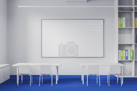 Photo for Interior of modern classroom with white walls, blue floor, row of white tables with chairs, bookcase and mock up whiteboard. 3d rendering - Royalty Free Image