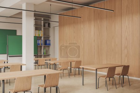 Téléchargez les photos : Intérieur d'une salle de classe élégante avec des murs beiges et en bois, sol en pierre, rangées de tables en bois avec chaises, bibliothèque et mur maquette. Rendu 3d - en image libre de droit
