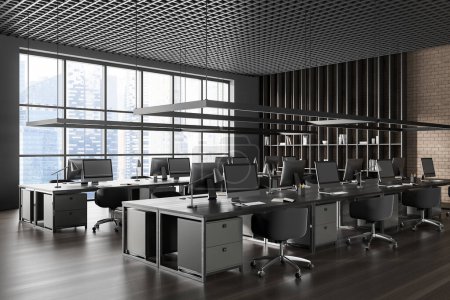 Photo for Dark coworking interior with armchairs and pc computer on shared desk in row, side view hardwood floor. Business office room with shelf and panoramic window on skyscrapers. 3D rendering - Royalty Free Image