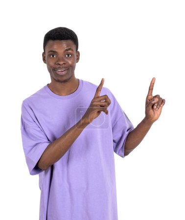 Photo for Smiling young black man in purple shirt, fingers pointing up. Isolated over white background. Concept of business offer and deal - Royalty Free Image
