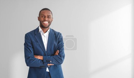 Téléchargez les photos : Portrait d'un jeune homme d'affaires afro-américain souriant, les bras croisés sur fond blanc. Maquette - en image libre de droit