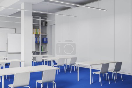 Téléchargez les photos : Intérieur de la salle de classe moderne avec murs blancs, plancher bleu, rangées de tables blanches avec chaises, bibliothèque et mur maquette. Rendu 3d - en image libre de droit