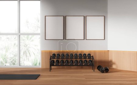 Photo for White wooden gym class interior with dumbbell storage rack and mat on hardwood floor. Sport room and panoramic window on tropics. Three mockup canvas banners in row. 3D rendering - Royalty Free Image