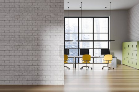 Foto de Acogedor interior de oficina con sillones y ordenador PC en fila. Zona de coworking con ventana panorámica y estantes, suelo de madera. Copiar espacio vacío tabique de pared de ladrillo. Renderizado 3D - Imagen libre de derechos