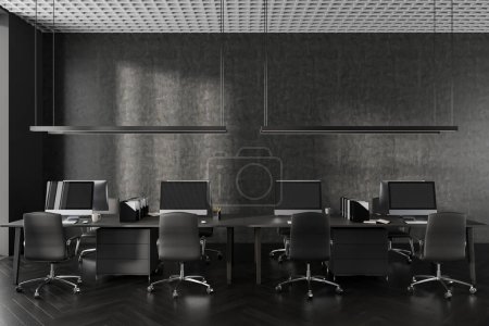 Foto de Interior oscuro de la oficina con sillones negros y computadora PC en el escritorio en fila, piso de madera dura. Moderno diseño de sala de coworking con muebles minimalistas. Renderizado 3D - Imagen libre de derechos