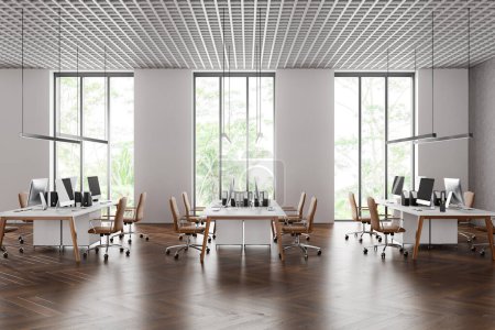 Foto de Interior de elegante oficina de espacio abierto con paredes blancas y de hormigón, suelo de madera oscura, fila de mesas de ordenador con sillas marrones y ventanas altas. renderizado 3d - Imagen libre de derechos